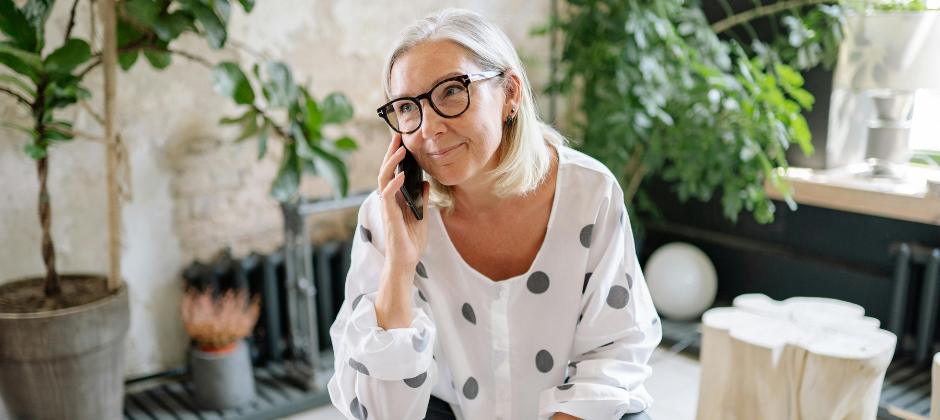 Kvinna med glasögon pratar i mobiltelefon